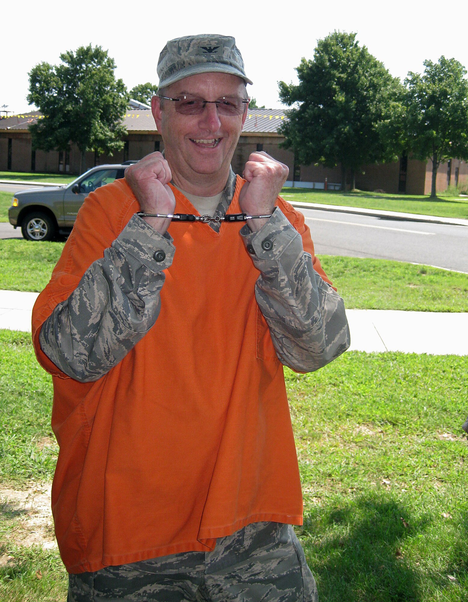 Col. Ellie Nix, 514th Mission Support Group commander, shows off his handcuffs after being “arrested” during the jail-and-bail fundraiser here Aug. 20. The purpose of the event was to raise funds for the Combat Dining-In, which is scheduled for Sept. 24. (U.S. Air Force photo/Tech. Sgt. Monica Dalberg)