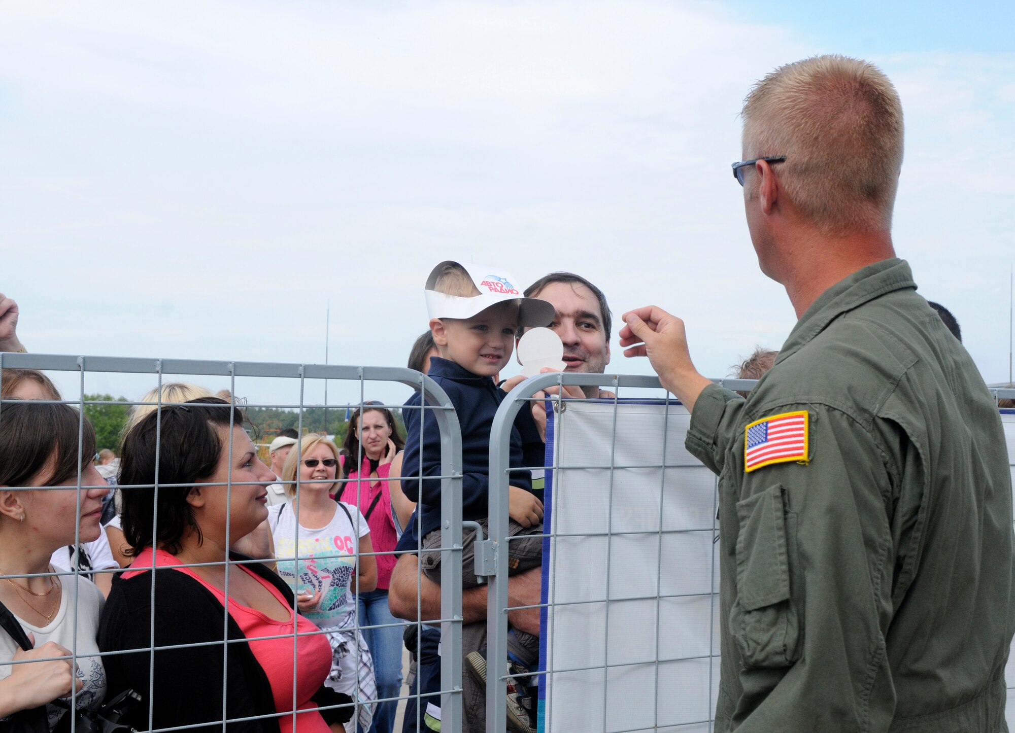 ZHUKOVSKY AIR FIELD, Russia – Tech. Sgt. Rob McGriffin, 9th Airlift Squadron from Dover Air Force Base, Del., gives a Russian child a sticker while he and his father wait in line to tour the C-5M Galaxy at the Moscow International Aviation and Space Salon, or MAKS 2011, here Aug. 20. MAKS is one of the premier events of its type in the world and Department of Defense participation demonstrates the United States commitment to international security, promotes international cooperation, and contributes to U.S. foreign policy objectives.  The U.S. Air Force has a KC-10 Extender, two F-16C Fighting Falcons, two A-10 Thunderbolt II, one F-15E Strike Eagle, one B-52 Stratotanker, C-130J Super Hercules, C-5M Galaxy, and a U.S. Navy P-3 Orion statics for the show. (U.S. Air Force photo/Master Sgt. Kelley J. Stewart)