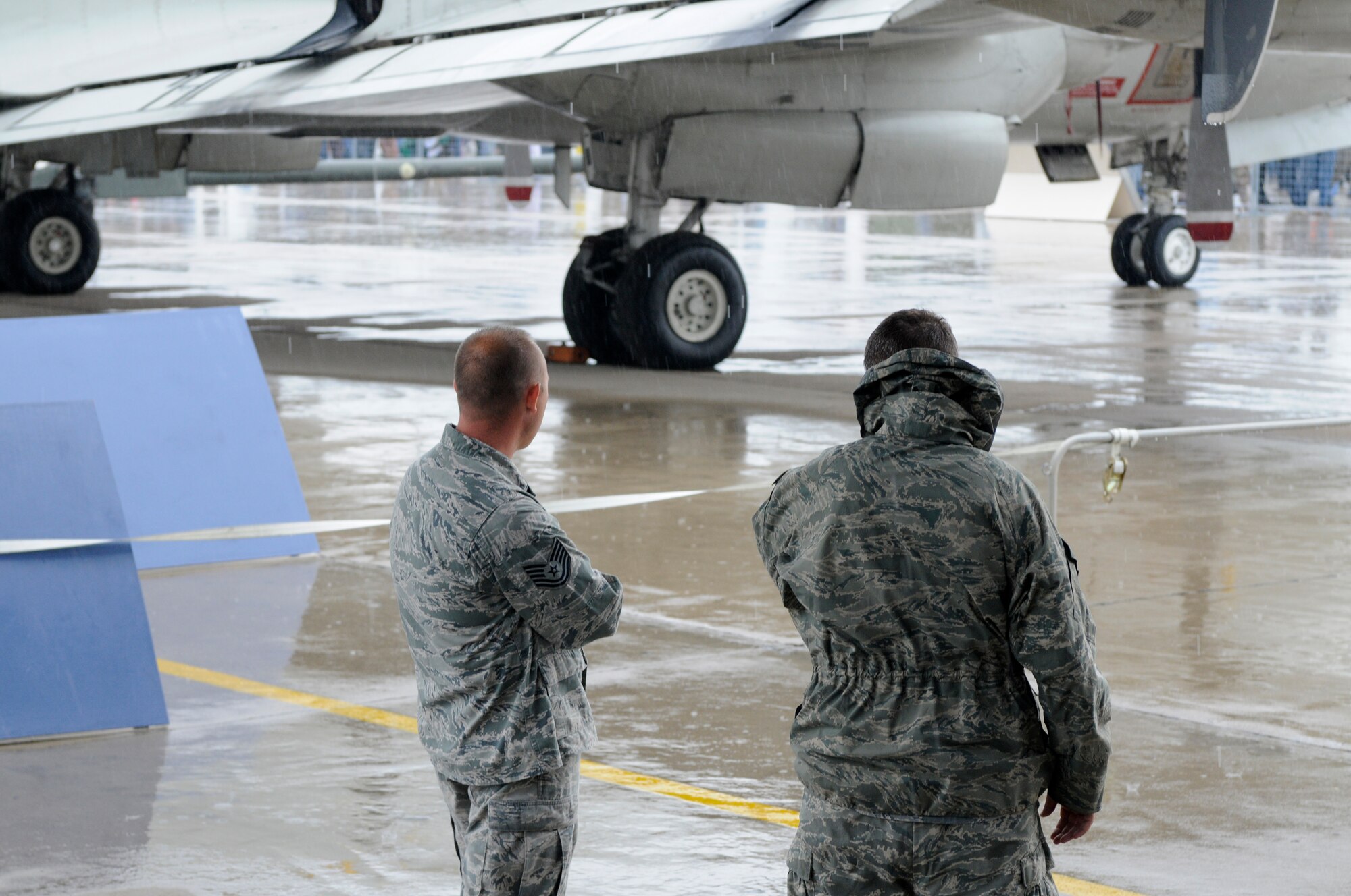 ZHUKOVSKY AIR FIELD, Russia – Airmen take cover under the wing of a C-130J from the 37th Airlift Squadron from Ramstein Air Base, Germany, at the Moscow International Aviation and Space Salon, or MAKS 2011, here Aug. 20. MAKS is one of the premier events of its type in the world and Department of Defense participation demonstrates the United States commitment to international security, promotes international cooperation, and contributes to U.S. foreign policy objectives.  The U.S. Air Force has a KC-10 Extender, two F-16C Fighting Falcons, two A-10 Thunderbolt II, one F-15E Strike Eagle, one B-52 Stratotanker, C-130J Super Hercules, C-5M Galaxy, and a U.S. Navy P-3 Orion statics for the show. (U.S. Air Force photo/Master Sgt. Kelley J. Stewart)