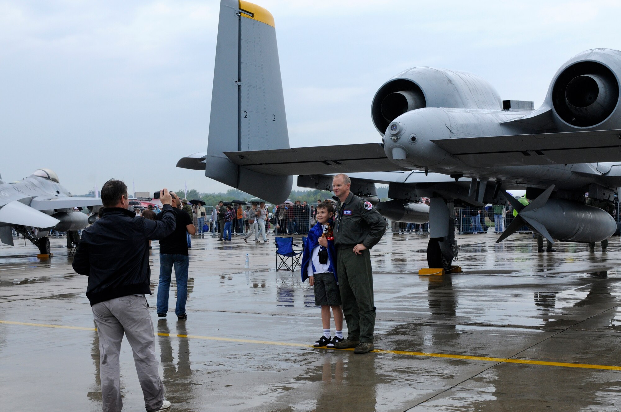 ZHUKOVSKY AIR FIELD, Russia – Col. Chris Weggeman, 52nd Fighter Wing commander and air boss, poses for a photo with a Russian child during the Moscow International Aviation and Space Salon, or MAKS 2011, here Aug. 20. MAKS is one of the premier events of its type in the world and Department of Defense participation demonstrates the United States commitment to international security, promotes international cooperation, and contributes to U.S. foreign policy objectives.  The U.S. Air Force has a KC-10 Extender, two F-16C Fighting Falcons, two A-10 Thunderbolt II, one F-15E Strike Eagle, one B-52 Stratotanker, C-130J Super Hercules, C-5M Galaxy, and a U.S. Navy P-3 Orion statics for the show. (U.S. Air Force photo/Master Sgt. Kelley J. Stewart)