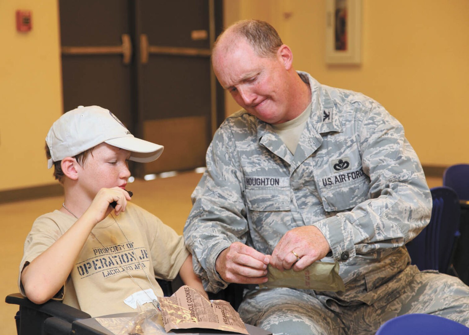 Col. Richard Houghton, 802nd Mission Support Group commander, helps his son, Ricky, with a Meal-Ready-to-Eat. (U.S. Air Force photo/Robbin Cresswell)