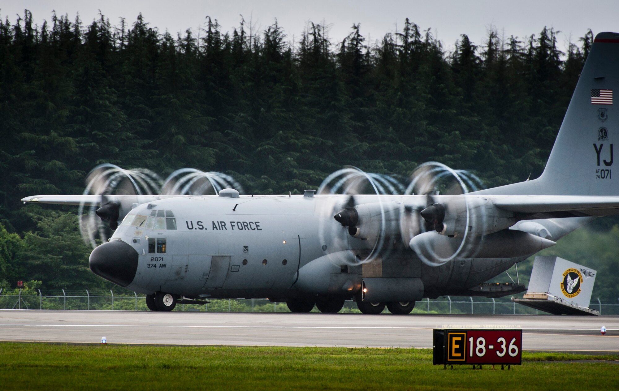 YOKOTA AIR BASE, Japan -- A C-130 Hercules performs a demonstration of a combat offload Aug. 21, 2011, during the Japanese-American Friendship Festival at Yokota Air Base, Japan. In a combat offload, the pilot of the C-130 boosts the throttle to full while the brakes are applied, and then releases the brakes using inertia to push cargo out the open back door of the aircraft. (U.S. Air Force photo/Staff Sgt. Samuel Morse)
