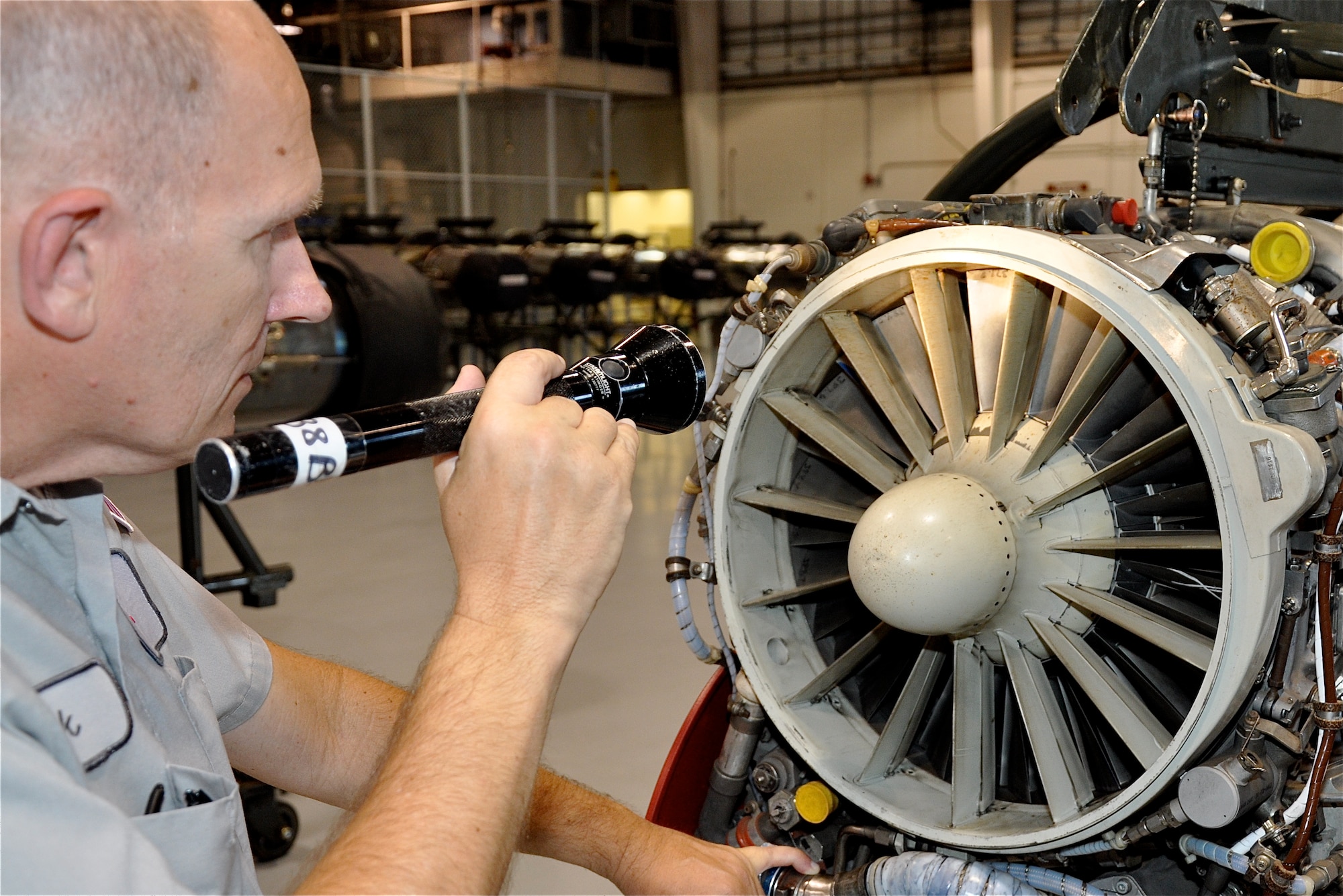 Rick Boardman inspects compressor blades in the J-85 jet engine for any deformities from debris. Boardman is the CSC Applied Technologies leadsman for the Jet Engine shop at Vance AFB, Okla. Compressor blades suck in and compress the air as it passes though the jet engine to create thrust. (U.S. Air Force photo/ Airman 1st Class Frank John Casciotta)
