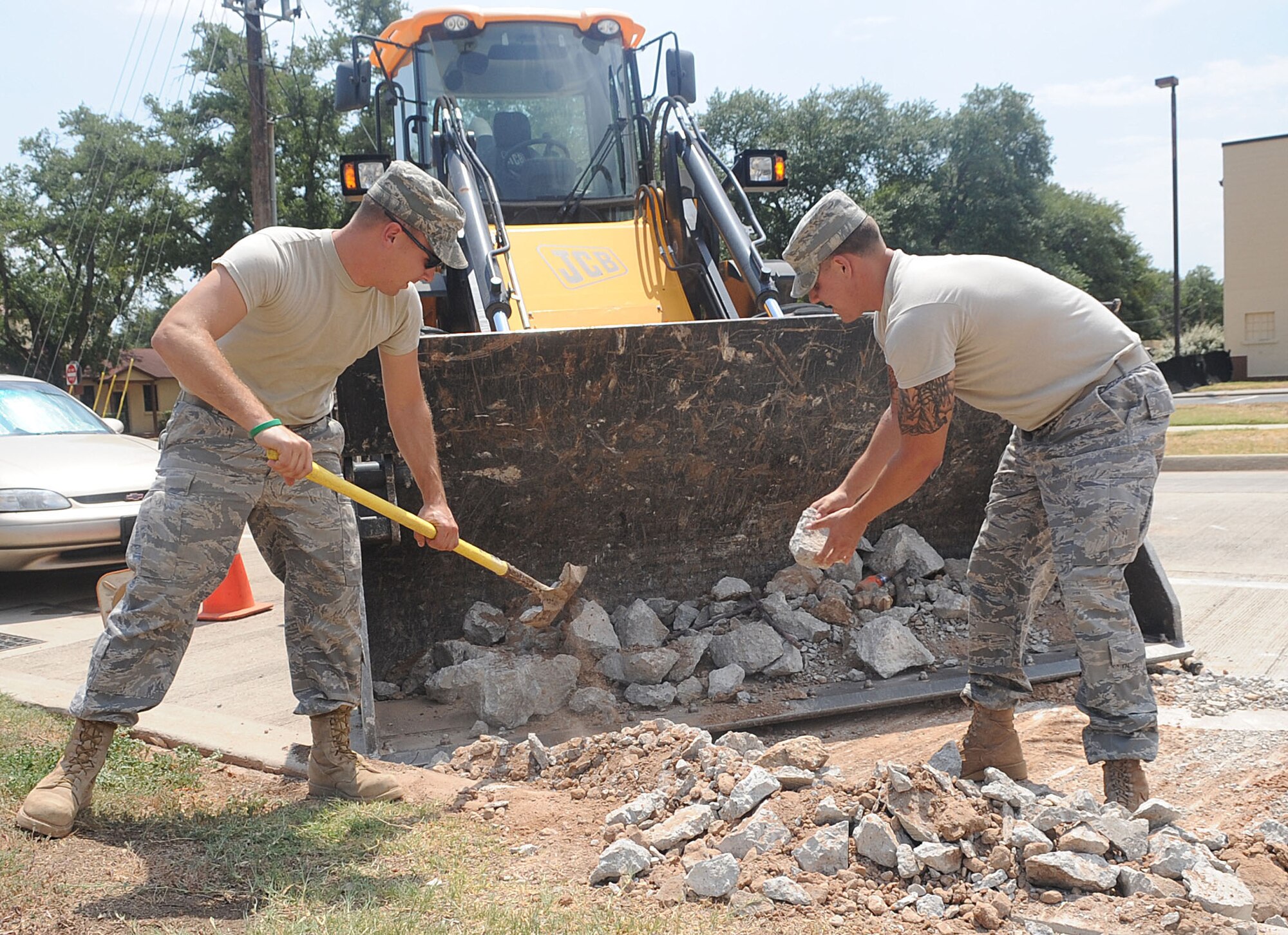 Staff Sgt. Thomas Zweydoff and Airman 1st Class Jon Dones, both of 2nd Civil Engineer Squadron, shovel gravel in front of the Information Operation Center on Barksdale Air Force Base, La., Aug. 18. There are currently 12 active projects on base being worked on by Civil Engineer troops, totalling approximately $250,000 in materials and man hours.(U.S. Air Force photo/Senior Airman Kristin High)(RELEASED)