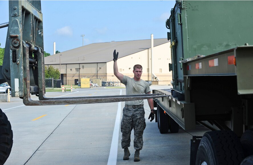 U.S. Air Force Airman 1st Class Spencer Kling, 23rd Logistics Readiness Squadron vehicle operator, marshals a vehicle operator driving a forklift to lift cargo off the trailer at Moody Air Force Base, Ga., Aug. 18, 2011. The cargo is taken to the deployment control center to be weighed and inspected before being shipped to Nellis Air Force Base, Nev., for the Green Flag exercise. (U.S. Air Force photo by Senior Airman Stephanie Mancha/Released)