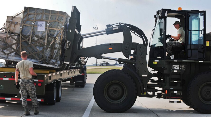 U.S. Air Force Airman 1st Class Spencer Kling, 23rd Logistics Readiness Squadron vehicle operator, spots Staff Sgt. Cory Hall, 23rd LRS vehicle operator, as he uses the forklift to move cargo off the trailer to be weighed at the deployment control center (DCC) at Moody Air Force Base, Ga., Aug. 18, 2011. Hall and Kling packed the cargo onto the trailer and drove it to the DCC for it to be weighed and inspected. (U.S. Air Force photo by Senior Airman Stephanie Mancha/Released)