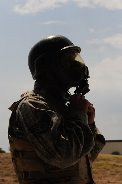Staff Sgt. James Shields, 2nd Maintenance Squadron, dons a gas mask at the firing range on Barksdale Air Force Base, La., Aug 18. Students at the Combat Arms Training and Maintenance range fired the M-16A2 rifle while wearing a gas mask to acclimate them with aiming the weapon in a contaminated environment. (U.S. Air Force photo/Airman 1st Class Micaiah Anthony)(RELEASED) 