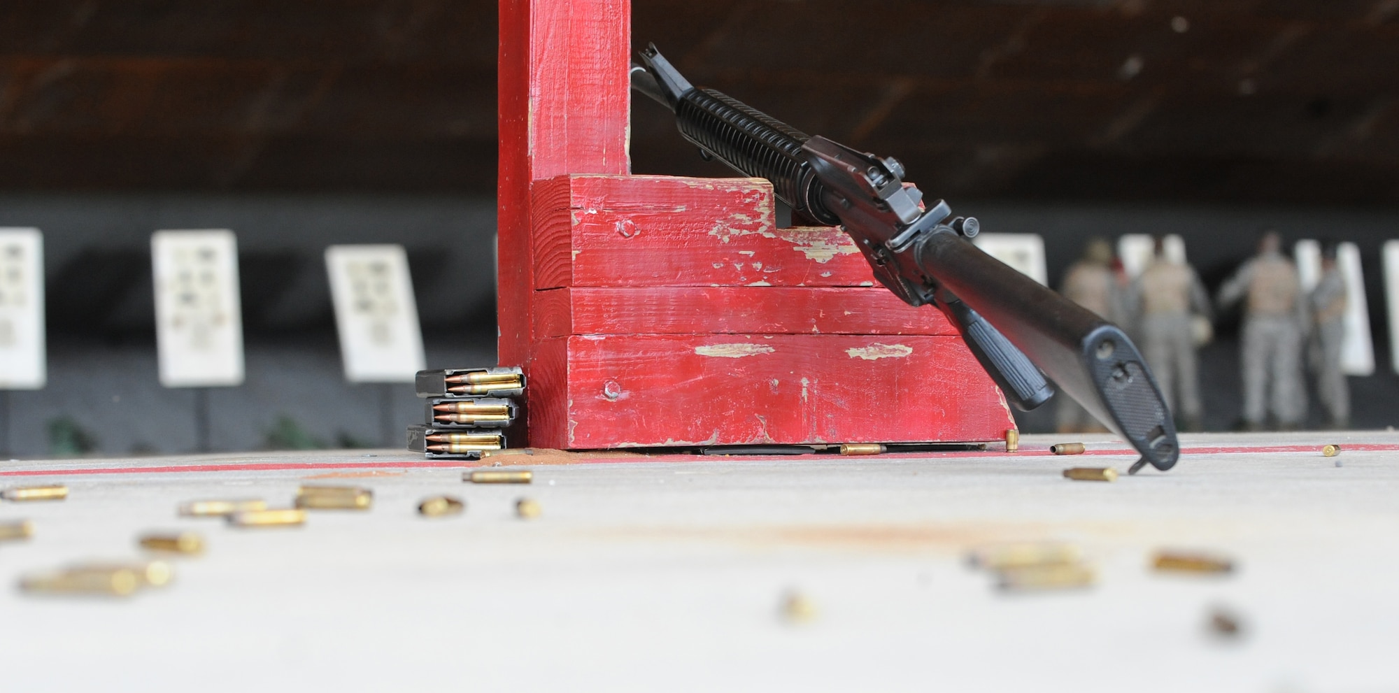 An M-16A2 rifle rests against a post while Airmen listen to instructions from a Combat Arms Training and Maintenance instructor at the firing range on Barksdale Air Force Base, La., Aug. 18. The M-16A2 rifle has a maximum affective range of 3,600 meters, which is equivalent to 39 football fields. (U.S. Air Force photo/Airman 1st Class Micaiah Anthony)(RELEASED)