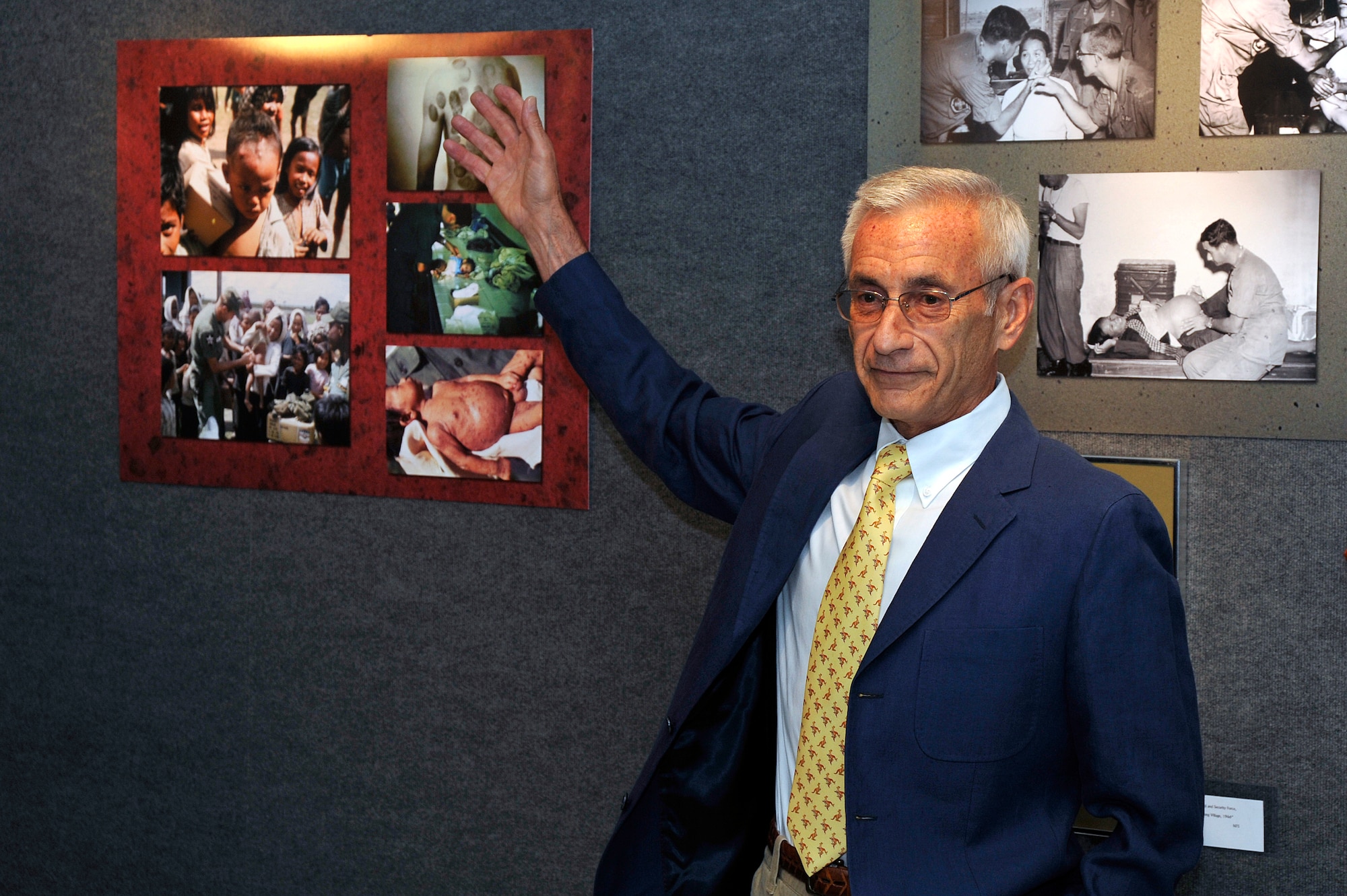 Dr. Carl Bartecchi talks to guests about his photos from Vietnam during a reception Aug. 16, 2011, at the Air Force Academy's Permanent Professors Art Gallery. The gallery currently houses an exhibit displaying photos, artwork and items collected by Bartecchi, the author of "A Doctor's Vietnam Journal," during his multiple trips to Vietnam. (U.S. Air Force photo/Bill Evans)