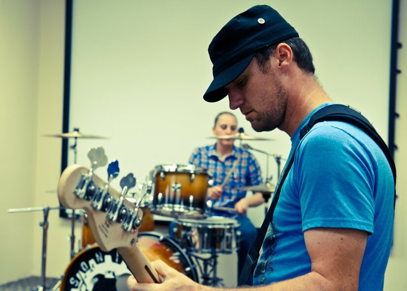 Senior Airman Shane Goss, of the 96th Civil Engineer Squadron, plays the bass guitar and Senior Airman Brittany Caruso, of the 96th Logistics Readiness Squadron, plays the drums in their band, Sonic Cell.  The four-person alternative rock band is made up of enlisted Airmen from the 96th Air Base Wing.  (U.S. Air Force photo/Samuel King Jr.)