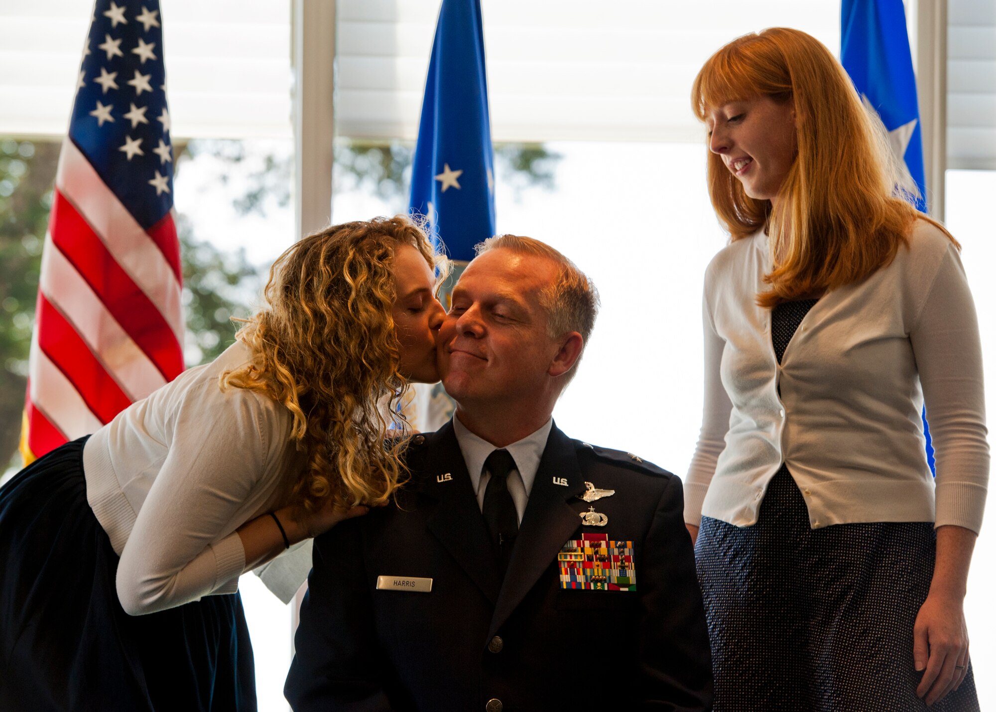 Newly-ranked Brig. Gen. David Harris, the Air Armament Center vice commander, receives a kiss from his daughter after having his stars attached during his pin-on ceremony Aug. 19 at Eglin Air Force Base, Fla.  (U.S. Air Force photo/Samuel King Jr.)
