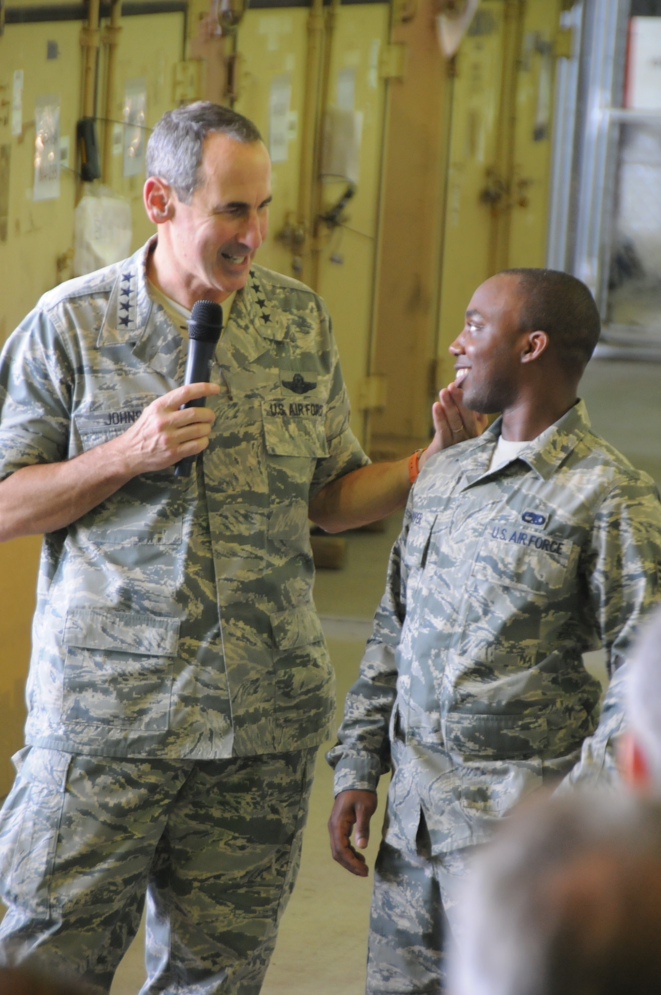 Gen. Raymond E. Johns Jr., Air Mobility Command commander, congratulates Staff Sgt. Demetrius Cooper of the 313th Air Expeditionary Wing on aircraft maintenance improvements at a non-disclosed base in Western Europe on Aug. 16, 2011. The general answered questions and addressed issues and concerns and also thanked Airmen for their service and the ability to answer the nation's call at a moments notice. The wing supports Operation Unified Protector, a NATO-led mission in Libya to protect civilians and civilian-populated areas under threat of attack. The 313th AEW provides aerial refueling to U.S. and coalition aircraft with KC-135 Stratotankers and KC-10 Extenders. (U.S. Air Force Photo/1st Lt. Rusty Ridley)