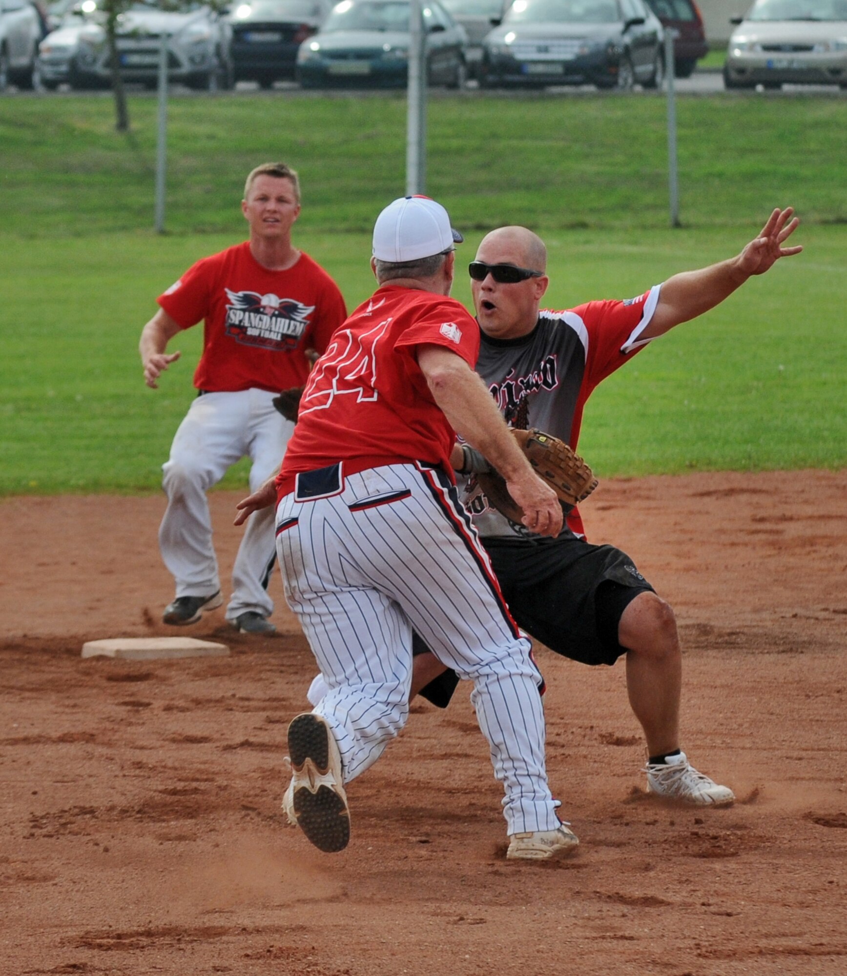SPANGDAHLEM AIR BASE, Germany – From left to right, Jacob Wilson, Spangdahlem Sabers second baseman, and John Downey, Spangdahlem Sabers midfielder, catch Wesley Cummins, Aviano Dodgers, out during a U.S. Forces Europe men’s softball round-robin tournament game here Aug. 18. The Sabers defeated the Dodgers 18-11. Both male and female U.S. Forces softball teams from the Army and Air Force, including a male and female Spangdahlem Saber team, participated in the annual event.  (U.S. Air Force photo/Senior Airman Nick Wilson)