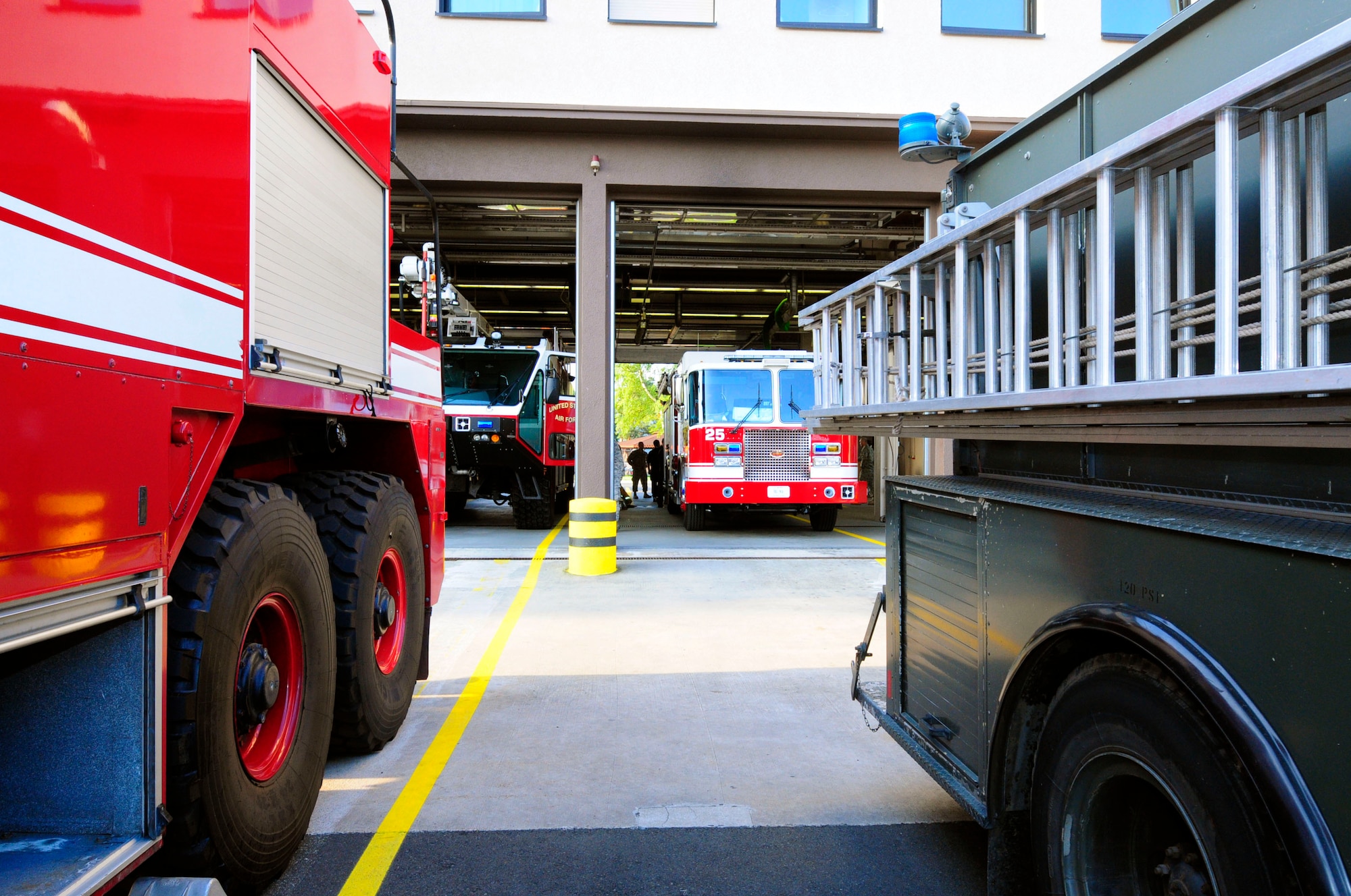 Two new fire trucks sit in a fire station while two retired trucks sit outside after a ceremony was held by the Ramstein Fire Department, Ramstein Air Base, Germany, Aug. 19, 2011. The ceremony was held to retire two fire trucks after 18 years of service and to bring two new trucks into service. (U.S. Air Force photo by Airman 1st Class Kendra Alba)
