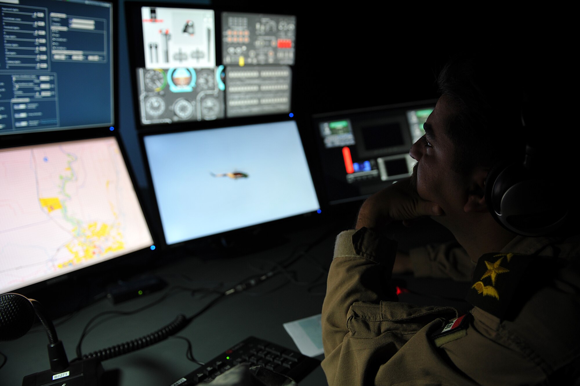 An Iraqi Army Aviation Command pilot, oversees simulation operations of a MI-171 helicopter simulator, as a pilot is run through a flight scenario at Taji Air Base, Iraq, Aug. 10, 2011. The simulator operator controls the flight simulation for the pilot in training, injecting flight control adjustments on the fly. The new $4.8 million simulator provides invaluable training to Iraqi Army Aviation Command pilots, allowing them to experience multiple flight scenarios, including emergency conditions in a controlled, safe environment. (U.S. Air Force photo/Tech. Sgt. Josef Cole)
