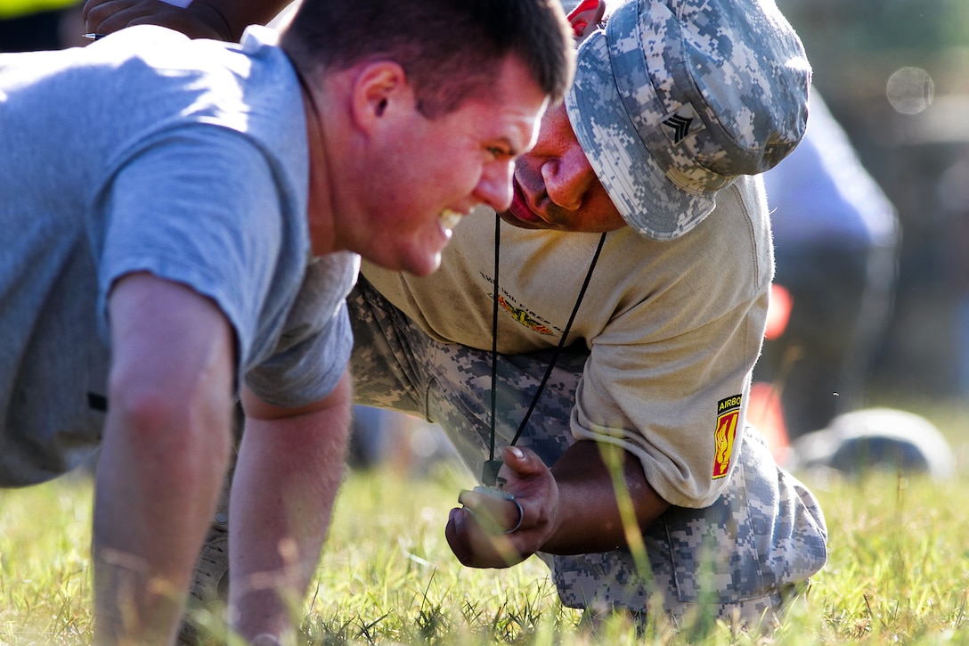 An Army grader, right, for the new Army's physical fitness test ensures ...