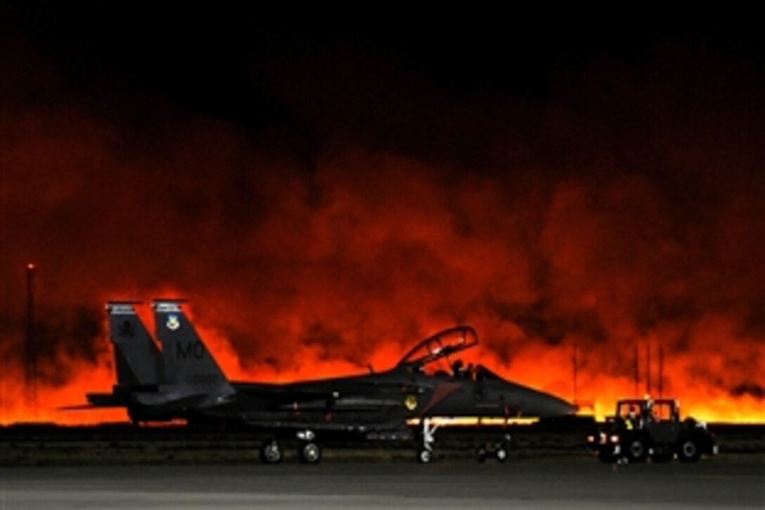 A Republic of Singapore Air Force F-15SG Strike Eagle aircraft sits on the flight line at at Mountain Home Air Force Base in Idaho, Aug. 15, 2011. A fire near the base shut down flying operations and personnel were evacuated from flight line buildings as the fire approached.