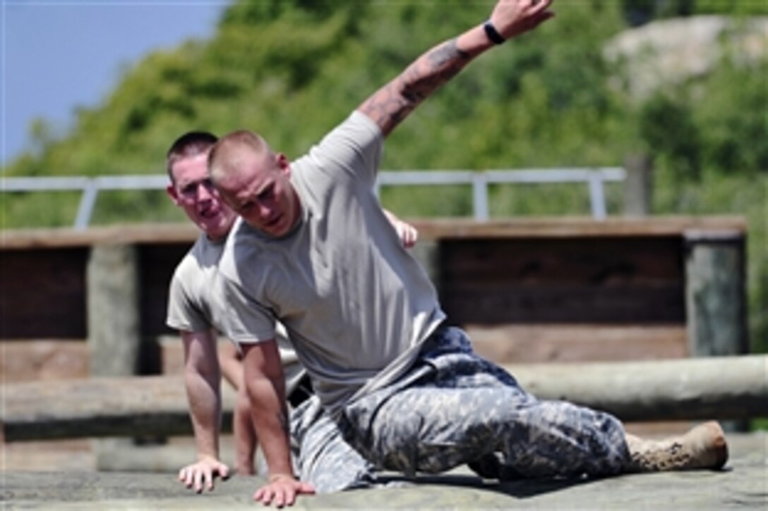 U.S. Army Staff Sgt. Jacob Vaughan, front, leads his team through an obstacle course during a first response training evolution in Guantanamo, Cuba, Aug. 16, 2011. Vaugh and his team are assigned to the 525th Military Police Battalion.