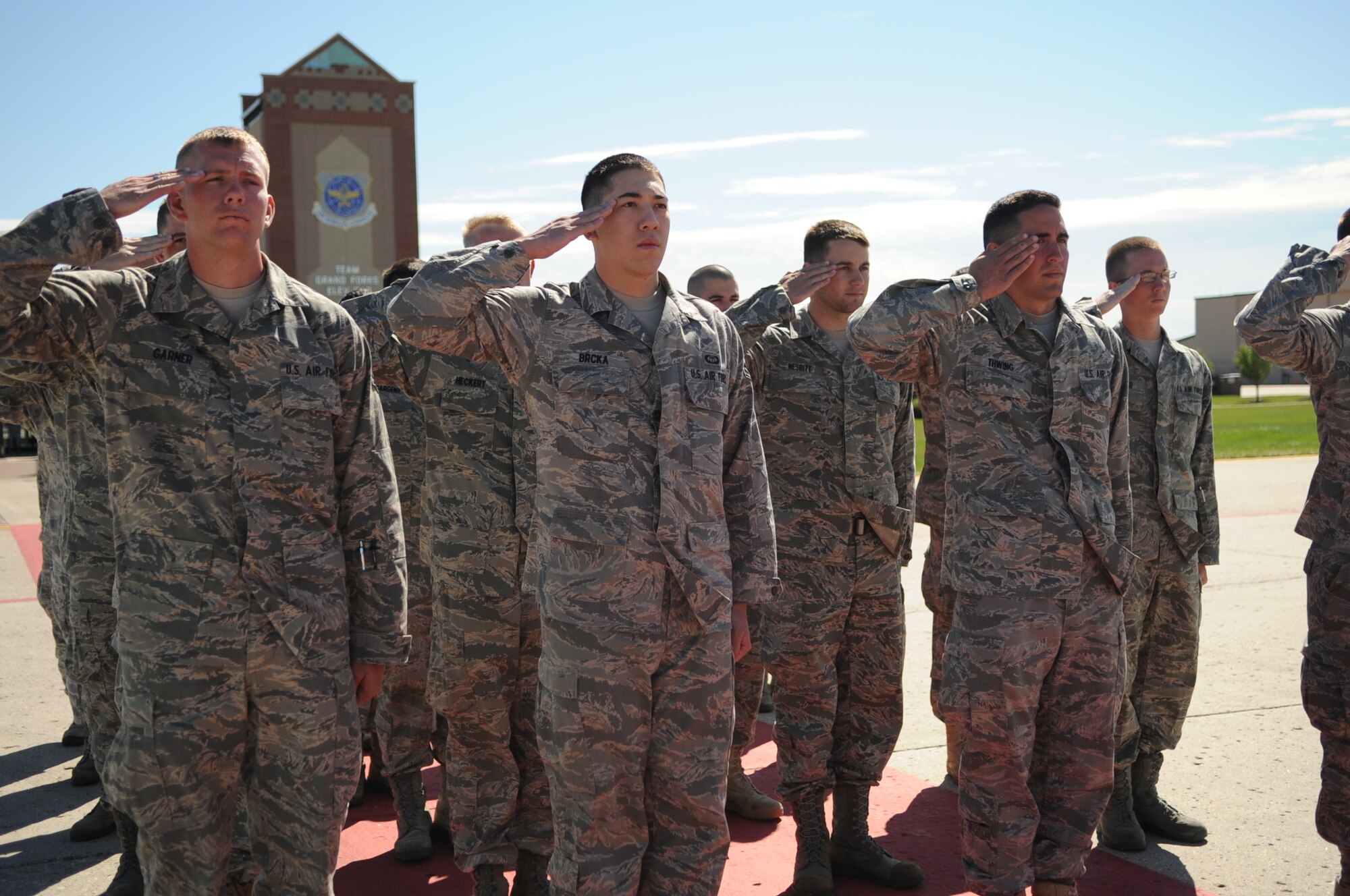 Members of the 319th Operations Support Squadron give their final salute to the former commander during the 319th OSS Change of Command on Grand Forks Air Force Base Aug 19. The Change of Command is a time-honored tradition in the military which visibly assures continuity of command. This is represented by the unit flag being passed from the present commander to the future commander. (U.S Air Force photo by Senior Airman Amanda N. Stencil)