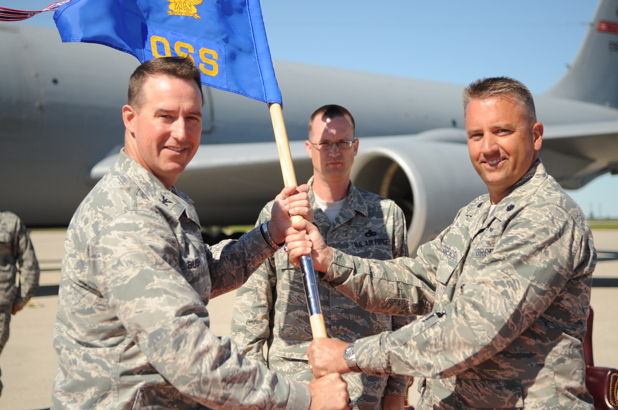 Lt. Col. Darin Driggers (right), Commander of the 319th Operation Support Squadron, hands over the guidon to Col. Timothy Bush, Commander of the 319th Air Base Wing during the 319th OSS Change of Command on Grand Forks Air Force Base Aug. 19. The Change of Command is a time-honored tradition in the military which visibly assures continuity of command. This is represented by the unit flag being passed from the present commander to the future commander. (U.S Air Force photo by Senior Airman Amanda N. Stencil)