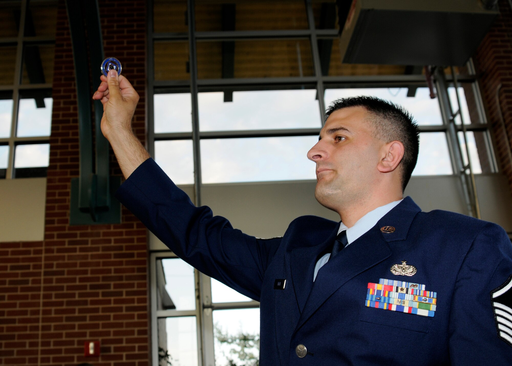 Master Sgt. Josh Rich, 188th Civil Engineering Squadron first sergeant, holds up the Air Force Civil Engineer coin during a formal dining-in ceremony held in Fort Smith.  The objective of the event was to help foster squadron camaraderie before the unit ventured to Tyndall Air Force Base, Fla., to participate in Exercise Silver Flag during annual training. (U.S. Air Force photo by Senior Master Sgt. Dennis Brambl)



