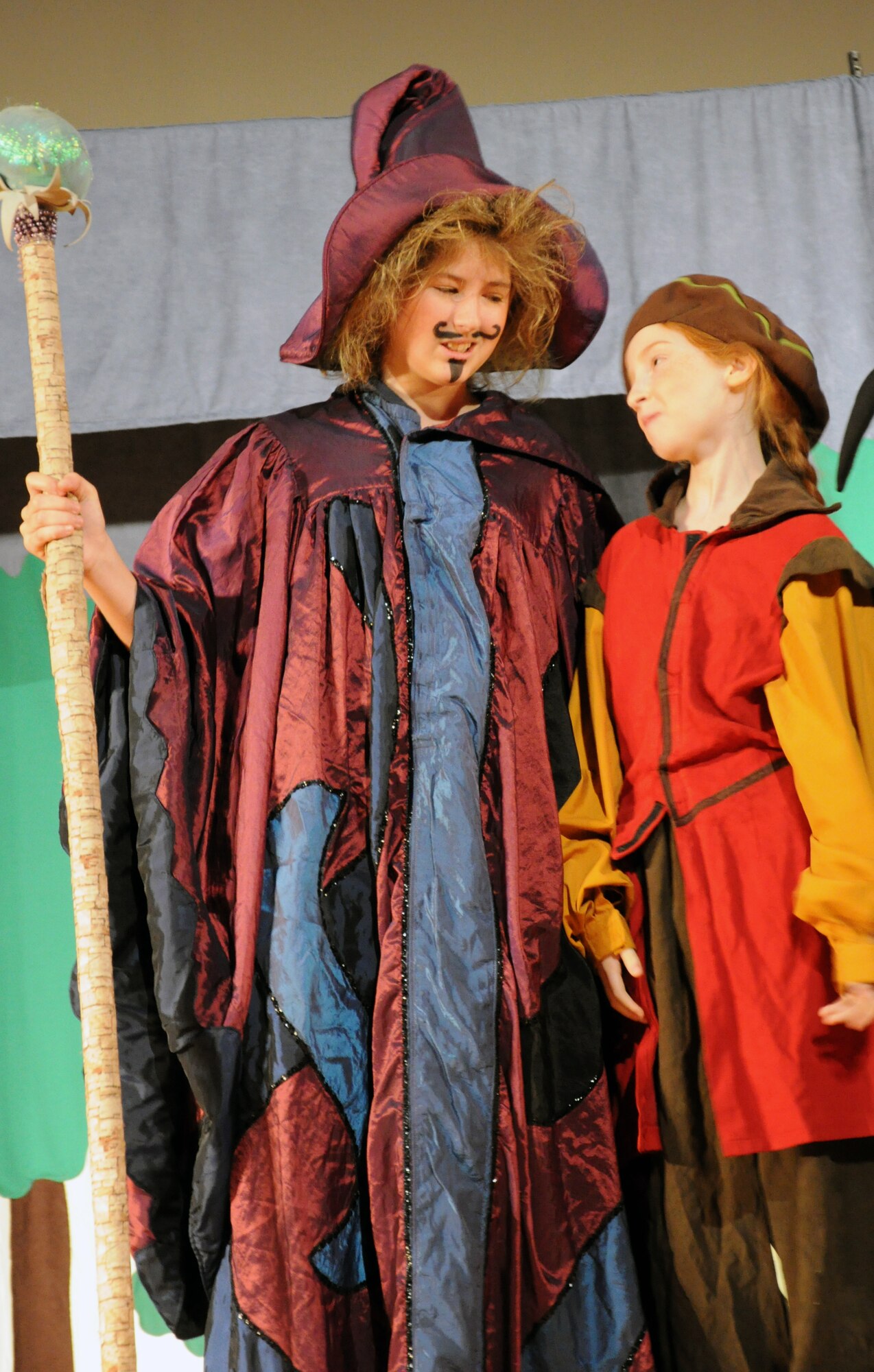 GOODFELLOW AIR FORCE BASE, Texas -- (From left:) Merlin, played by Mary Kate Willis, tells Taleisin, played by Katharine Ingalls, about plans for a new spell during the Missoula Children's Theatre production of King Arthur's Quest Sept. 20 at the base theater here.  The Missoula Children's Theatre had only one week with more than 50 youths cast in the play to prepare for two shows. (U.S. Air Force photo/Connie Hempel)