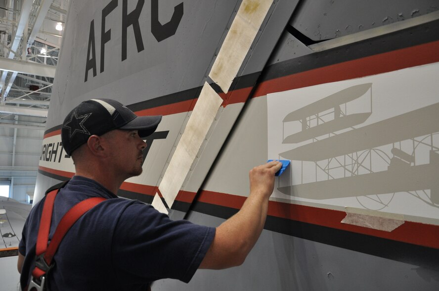 WRIGHT-PATTERSON AIR FORCE BASE, Ohio - Staff Sgt. Josh Hamilton, 445th Maintenance Squadron, readies the tail of a 445th Airlift Wing C-17 Globemaster III in preparation for painting the Wright Flyer logo on the tail. (U.S. Air Force photo/Staff Sgt. Amanda Duncan)
