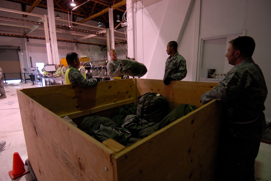 Airmen assigned as mobility baggage handlers for the 129th Rescue Wing's personnel deployment function, fill a pallet with baggage during an Operational Readiness Exercise at Moffett Federal Airfield, Calif., August 6, 2011.  (Air National Guard photo by Tech. Sgt. Ray Aquino)