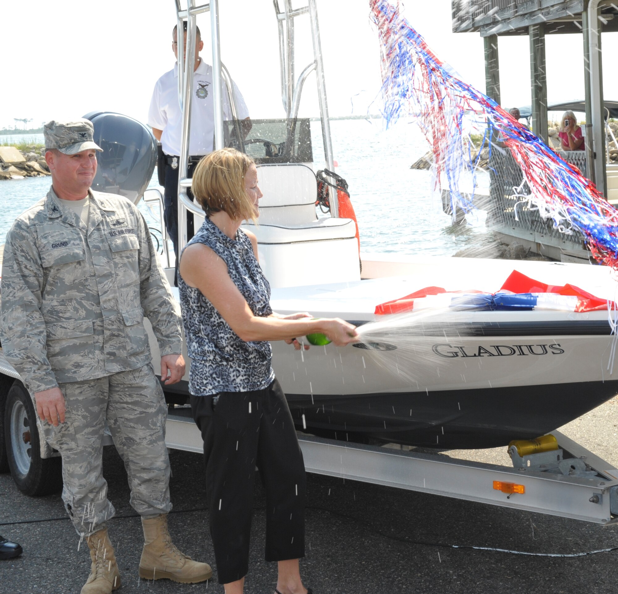 Teresa Grund, 325th Mission Support Group commander’s wife, christens the 325th Security Forces’ patrol boat, Gladius, during a christening ceremony at the marina, Aug. 19. (U.S. Air Force photo by Jonathan Gibson)