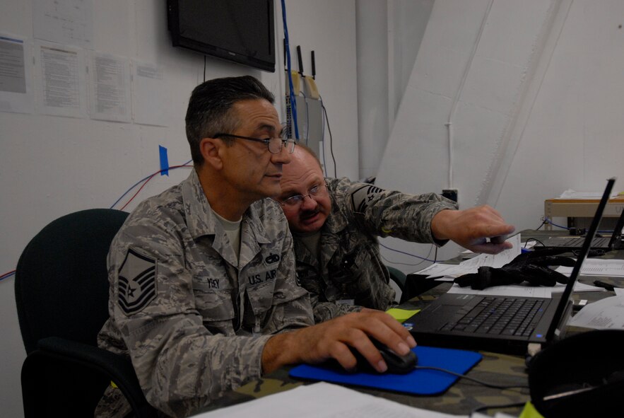 Master Sgt. Mike Yeihey and Master Sgt. Clarence Robinson, assigned with the 129th Logistics Readiness Squadron, prepare aircraft load plans to determine location of pallets and vehicles, based on weight, to ensure proper aircaft balance during an Operational Readiness Exercise at Moffett Federal Airfield, Calif., August 7, 2011.  (Air National Guard photo by Tech. Sgt. Ray Aquino)