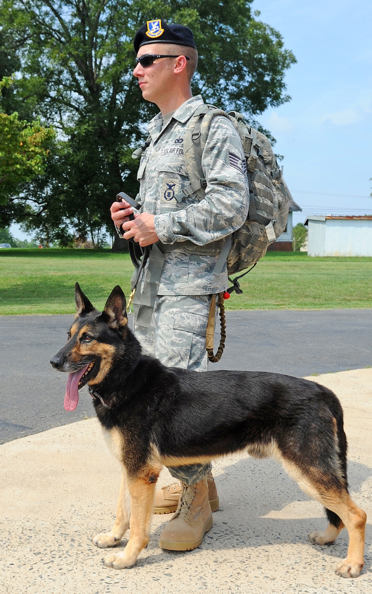 SEYMOUR JOHNSON AIR FORCE BASE, N.C. - Staff Sgt. Benjamin Seekell, 4th Security Forces Squadron dog handler, stands next to his military working dog, Charlie, prior to the passing of the guidon during the 9/11 Ruck March to Remember Aug. 21, 2011. Seekell and Charlie came out to support fellow defenders in arms in the march after being injured by a landmine in Afghanistan in May. The march began at Lackland Air Force Base, Texas and consists of 15 security forces squadrons covering 2,182 miles to ground zero in New York. Seekell hails from Charlestown, R.I. (U.S. Air Force photo by Senior Airman Gino Reyes/Released)