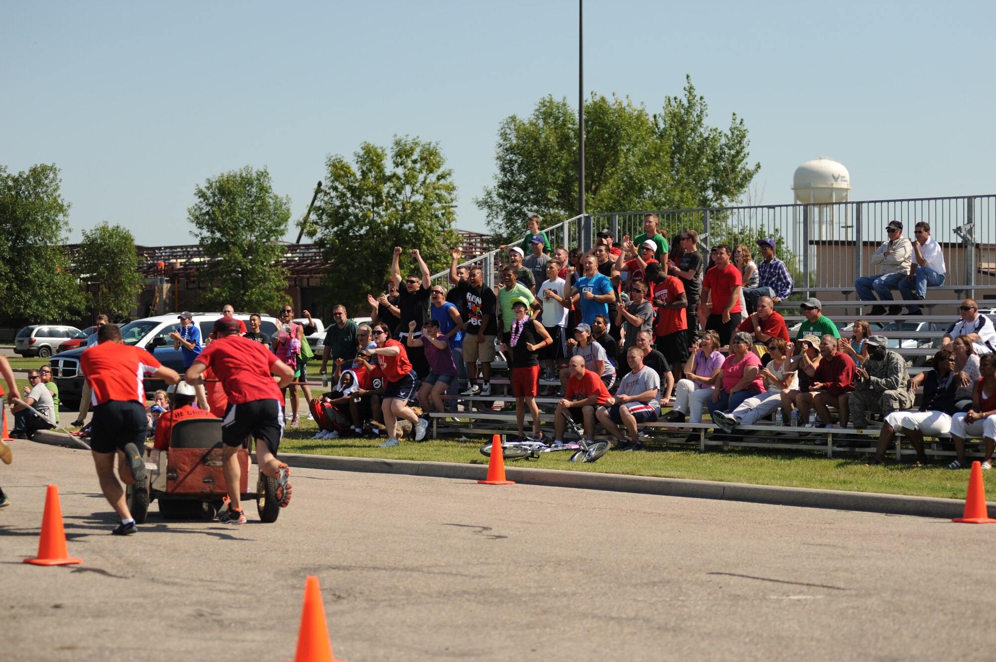 Members from the 319th Civil Engineering Squadron cheer for CE members competing in the bed race during Summer Bash on Grand Forks Air Force Base Aug 18. (U.S. Air Force photo by Senior Airman Amanda N. Stencil)