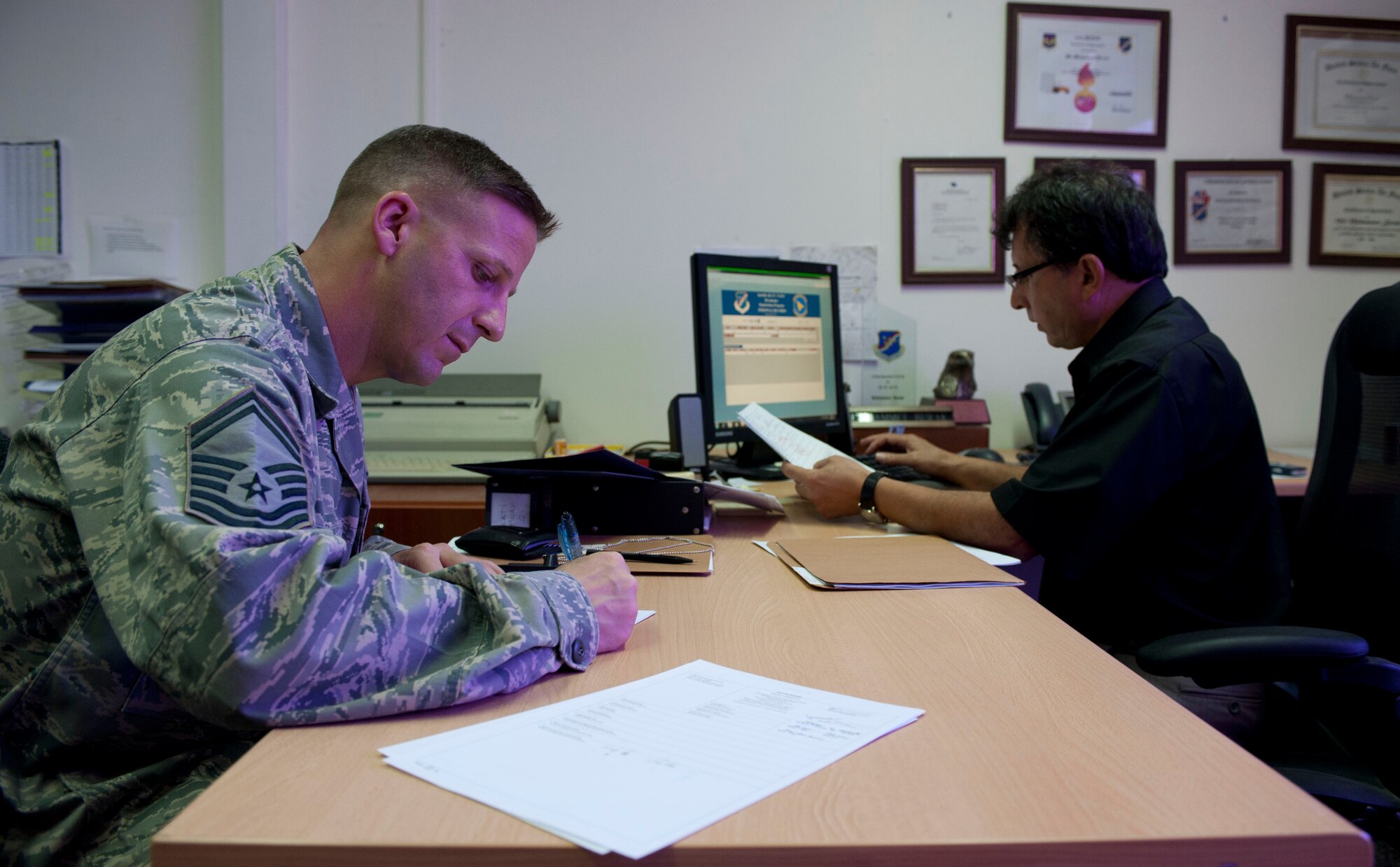 Muhammet Burak, 39th Logistics Readiness Squadron, files paperwork as Senior Master Sgt. Robert Miller, 728th Air Mobility Squadron, completes his Beyanname paperwork to clear his household goods before leaving the country. The Beyanname is a written declaration between Department of Defense-sponsored people and the Turkish government that provides customs control of certain personal items brought into the country.(U.S. Air Force photo by Airman 1st Class Clayton Lenhardt/Released)