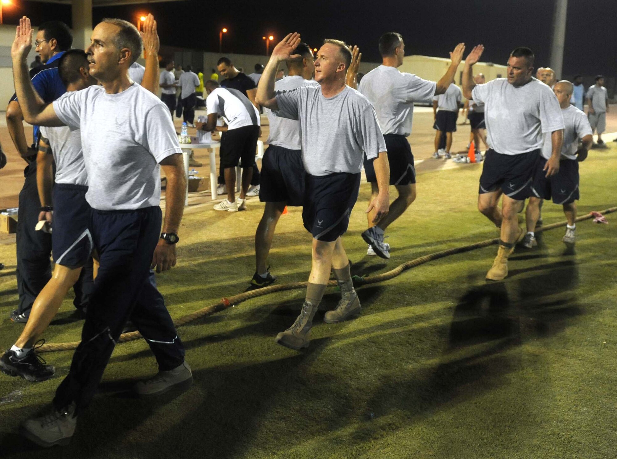 The 380th Air Expeditionary Wing chiefs' group team high-fives the 380th Expeditionary Civil Engineer Squadron team after winning a tug o' war match Aug. 9, 2011, during the 2011 Ramadan Games. After each victory the chiefs' group team paid respect to their opposing team with a post-game chant of the squadron or career field of their competitors. The Ramadan Games is an annual sporting competition put on at an air base in Southwest Asia in which teams from the 380th AEW, the 3rd Battalion, 4th Air Defense Regiment of the U.S. Army, the French air force and the host nation military compete in events including soccer, volleyball, tug o' war and swimming. (U.S. Air Force photo/Master Sgt. Chance Babin)