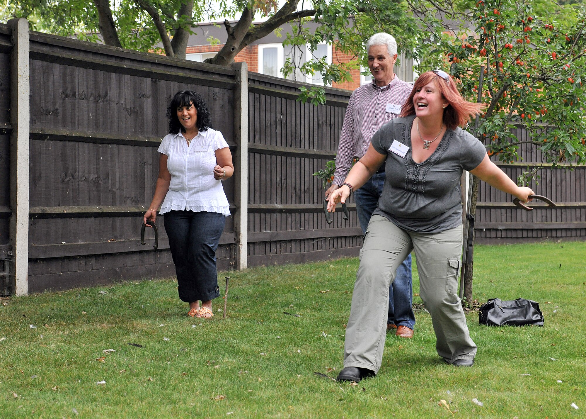 RAF MILDENHALL, England – Sharon Powell, wife of Chief Master Sgt. Christopher Powell, 100th Air Refueling Wing command chief, shows Councillor Keith Bovill, Mayor of Newmarket, and his wife Tracey, how to play horse shoes during the New Mayor’s Barbecue here Aug. 20, 2011. Col. Christopher Kulas and his wife, Nicole, hosted the barbecue for the newly-elected mayors and chairmen of the parish, district and county councils at their home. (U.S. Air Force photo/Staff Sgt. Tabitha M. Lee)