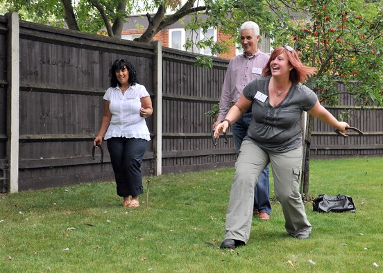 RAF MILDENHALL, England – Sharon Powell, wife of Chief Master Sgt. Christopher Powell, 100th Air Refueling Wing command chief, shows Councillor Keith Bovill, Mayor of Newmarket, and his wife Tracey, how to play horse shoes during the New Mayor’s Barbecue here Aug. 20, 2011. Col. Christopher Kulas and his wife, Nicole, hosted the barbecue for the newly-elected mayors and chairmen of the parish, district and county councils at their home. (U.S. Air Force photo/Staff Sgt. Tabitha M. Lee)