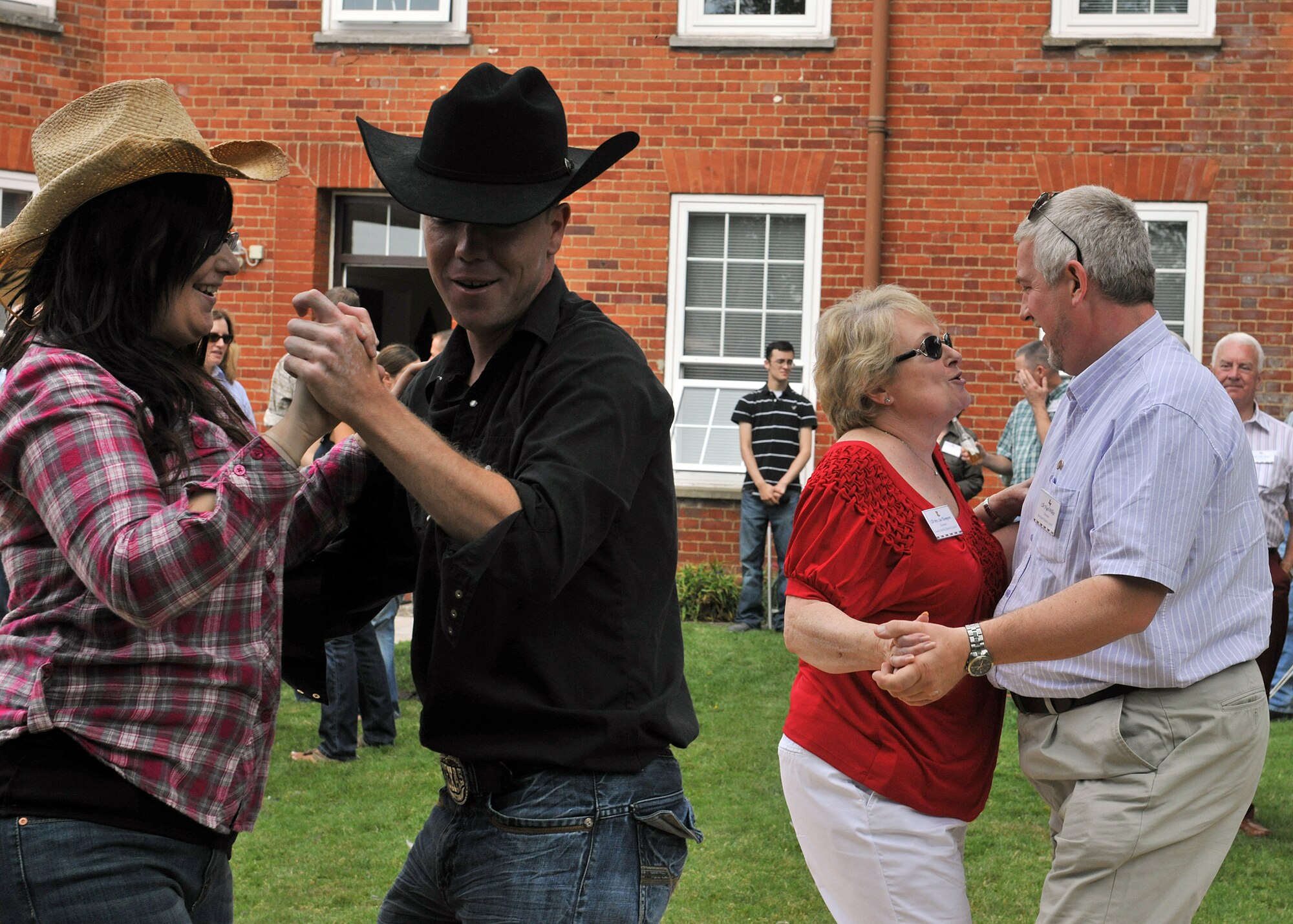 RAF MILDENHALL, England – Base members and local British community leadership do the Texas two-step at the New Mayor’s Barbecue here Aug. 20, 2011.  The event began with a mission brief, followed by a line dancing demonstration and concluded with lunch. (U.S. Air Force photo/Staff Sgt. Tabitha M. Lee)