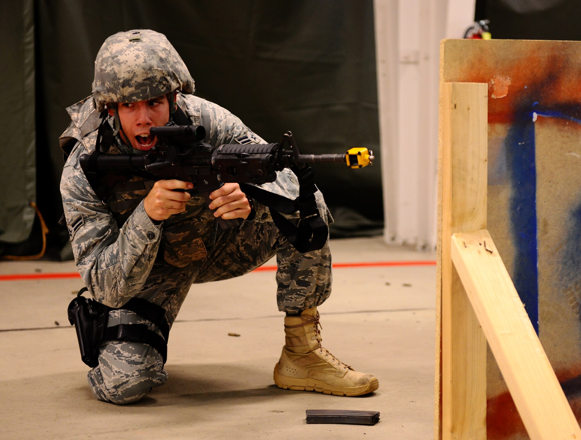 SPANGDAHLEM AIR BASE, Germany -- Airman 1st Class Conrad Gary, 52nd Security Forces Squadron patrolman, shouts orders to his team during a “Shoot, Move, Communicate” training course here Aug. 22. The training teaches Airmen to react to a hostile shooter by using cover and effective communication to maneuver and engage the target. (U.S. Air Force photo/Staff Sgt. Nathanael Callon)