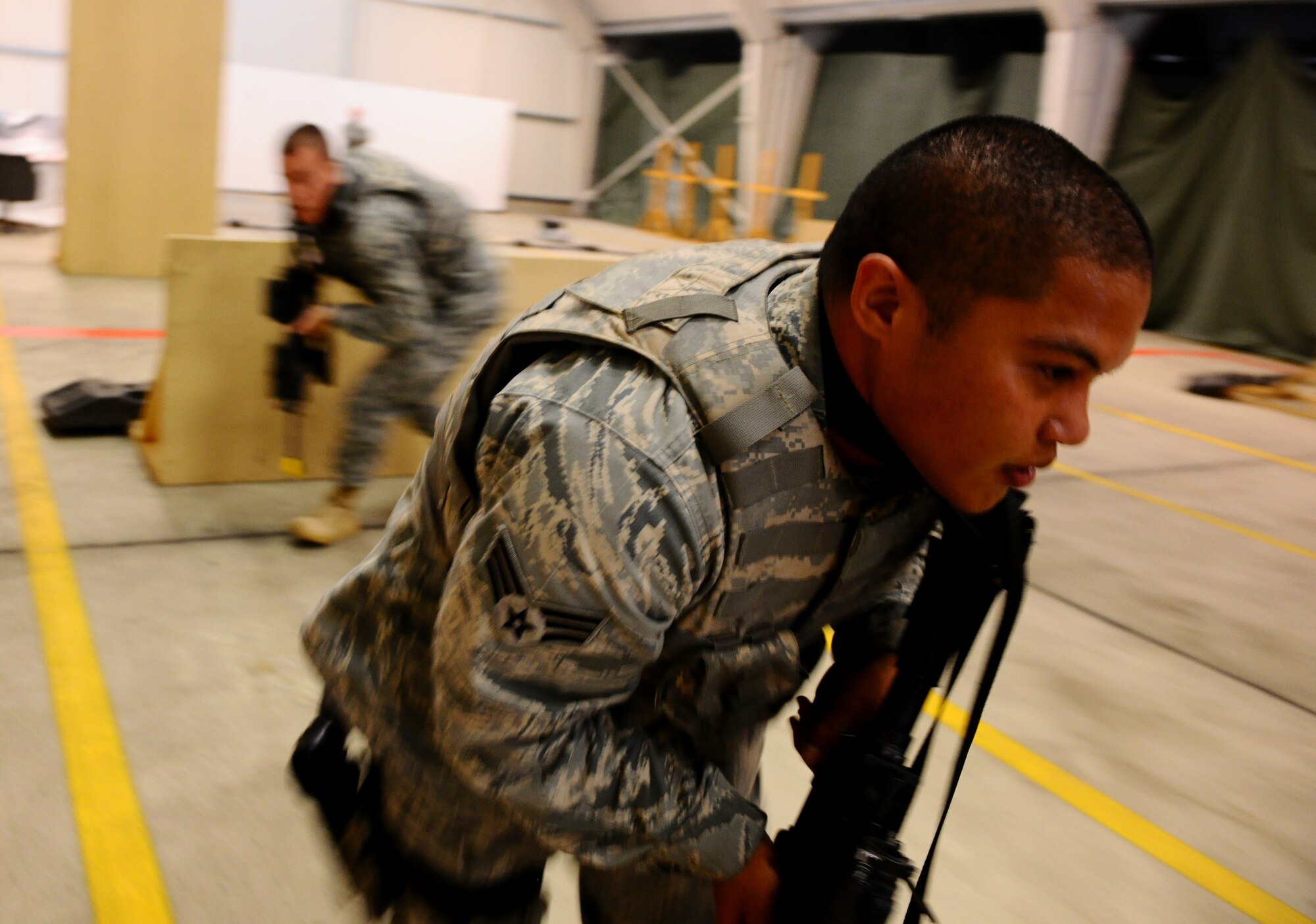 SPANGDAHLEM AIR BASE, Germany -- Senior Airman Andres Emayo, foreground, and Airman 1st Class Conrad Gary, 52nd Security Forces Squadron patrolmen, rush to the closest protection during “Shoot, Move, Communicate” training here Aug. 22. The training teaches Airmen to react to a hostile shooter by using cover and effective communication to maneuver and engage the target. (U.S. Air Force photo/Staff Sgt. Nathanael Callon)