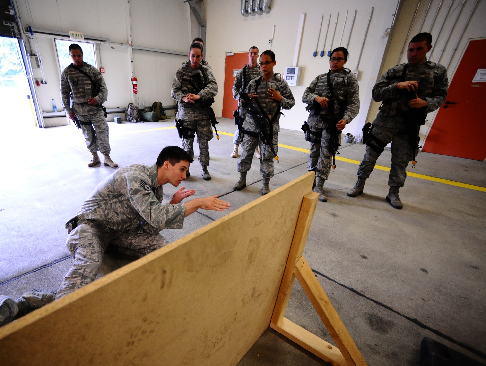 SPANGDAHLEM AIR BASE, Germany -- Staff Sgt. Adam Fagan, 52nd Security Forces Squadron training instructor, demonstrates to Airmen a method of firing while remaining behind protection during a “Shoot, Move, Communicate” training course here Aug. 22. The training teaches Airmen to react to a hostile shooter by using cover and effective communication to maneuver and engage the target. (U.S. Air Force photo/Staff Sgt. Nathanael Callon)