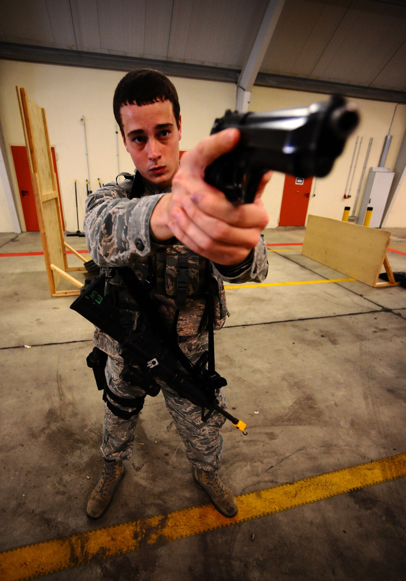 SPANGDAHLEM AIR BASE, Germany -- Airman 1st Class Alec Cox, 52nd Security Forces Squadron patrolman, aims his Beretta M-9 pistol during a “Shoot, Move, Communicate” training course here Aug. 22. The training teaches Airmen to react to a hostile shooter by using cover and effective communication to maneuver and engage the target. (U.S. Air Force photo/Staff Sgt. Nathanael Callon)