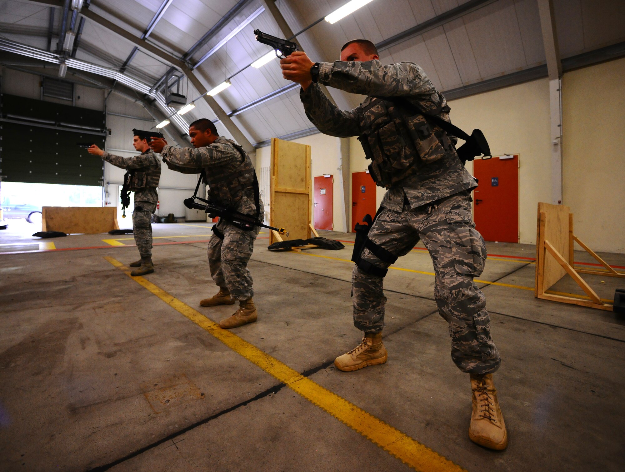 SPANGDAHLEM AIR BASE, Germany -- Airmen from the 52nd Security Forces Squadron practice aiming their Beretta M-9 pistols during a “Shoot, Move, Communicate” training course here Aug. 22. The training teaches Airmen to react to a hostile shooter by using cover and effective communication to maneuver and engage the target. (U.S. Air Force photo/Staff Sgt. Nathanael Callon)