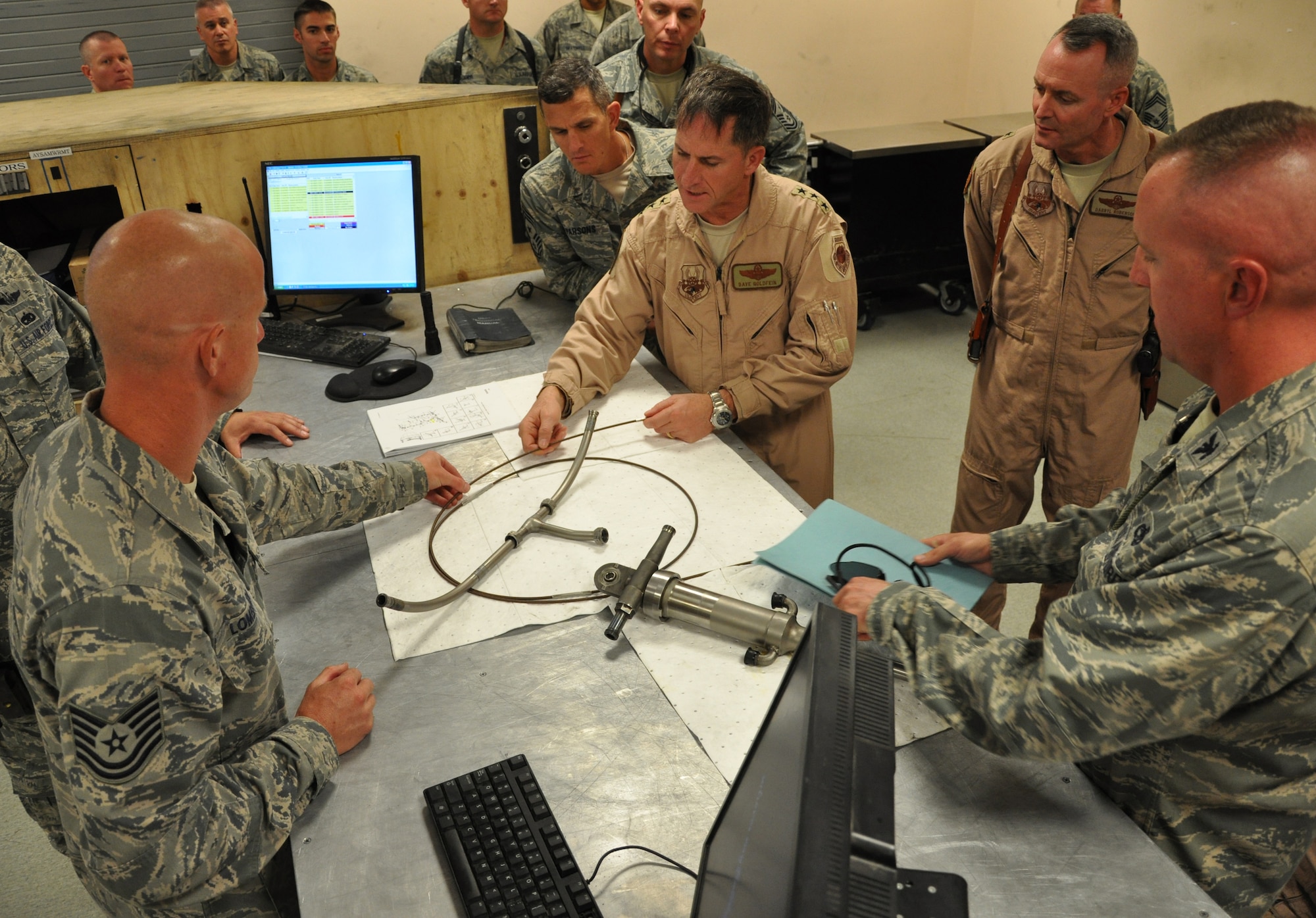 BAGRAM AIRFIELD, Afghanistan -- Tech. Sgt. Joshua Lombardi, 455th Expeditionary Aircraft Maintenance Squadron, Aerospace Propulsion craftsman, explains an aircraft part repair to Lt. Gen. David Goldfein, commander of U.S. Air Forces Central Command, Aug. 21, 2011, during his tour of the U.S. Central Command area of responsibility. Lombardi is California City, Calif., native deployed from the 31st Aircraft Maintenance Squadron at Aviano Air Base, Italy.  (U.S. Air Force photo/Staff Sgt. John Wright) 