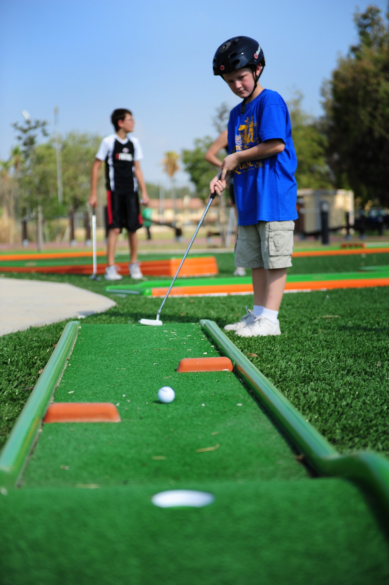 Son of Lt. Col. Brian Lindsey, 728th Air Mobility Squadron commander, putts a golf ball during a Bicycle Safety Rodeo Aug. 20, 2011, at Incirlik Air Base, Turkey. Rodeo participants played a game of miniature golf at the rodeo. Bicycle safety tips were placed in each hole to read and discuss upon sinking the ball into the hole. (U.S. Air Force photo by Senior Airman Anthony Sanchelli/Released) 