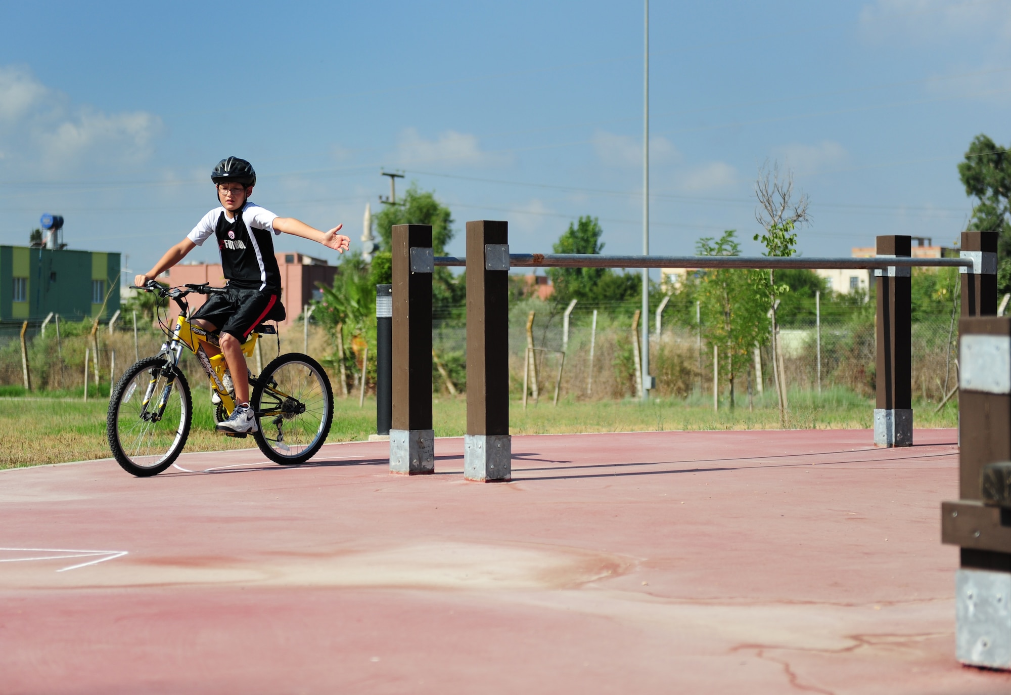 Son of Lt. Col. Brian Lindsey, 728th Air Mobility Squadron commander, uses proper hand signals during a Bicycle Safety Rodeo Aug. 20, 2011, at Incirlik Air Base, Turkey. Rodeo participants were shown the proper use of hand signals used to let motorists and other cyclists know their intentions on the road. (U.S. Air Force photo by Senior Airman Anthony Sanchelli/Released) 