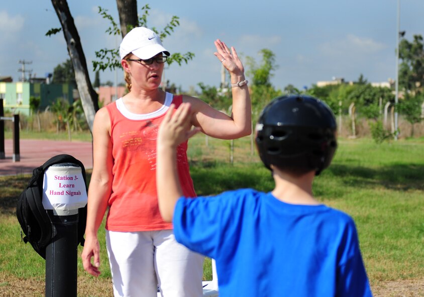 Master Sgt. Amanda Lopez, 39th Air Base Wing NCO in charge of military justice, demonstrates the proper hand signals during a Bicycle Safety Rodeo Aug. 20, 2011, at Incirlik Air Base, Turkey. Rodeo participants were shown the proper use of hand signals used to let motorists and other cyclists know their intentions on the road. (U.S. Air Force photo by Senior Airman Anthony Sanchelli/Released) 