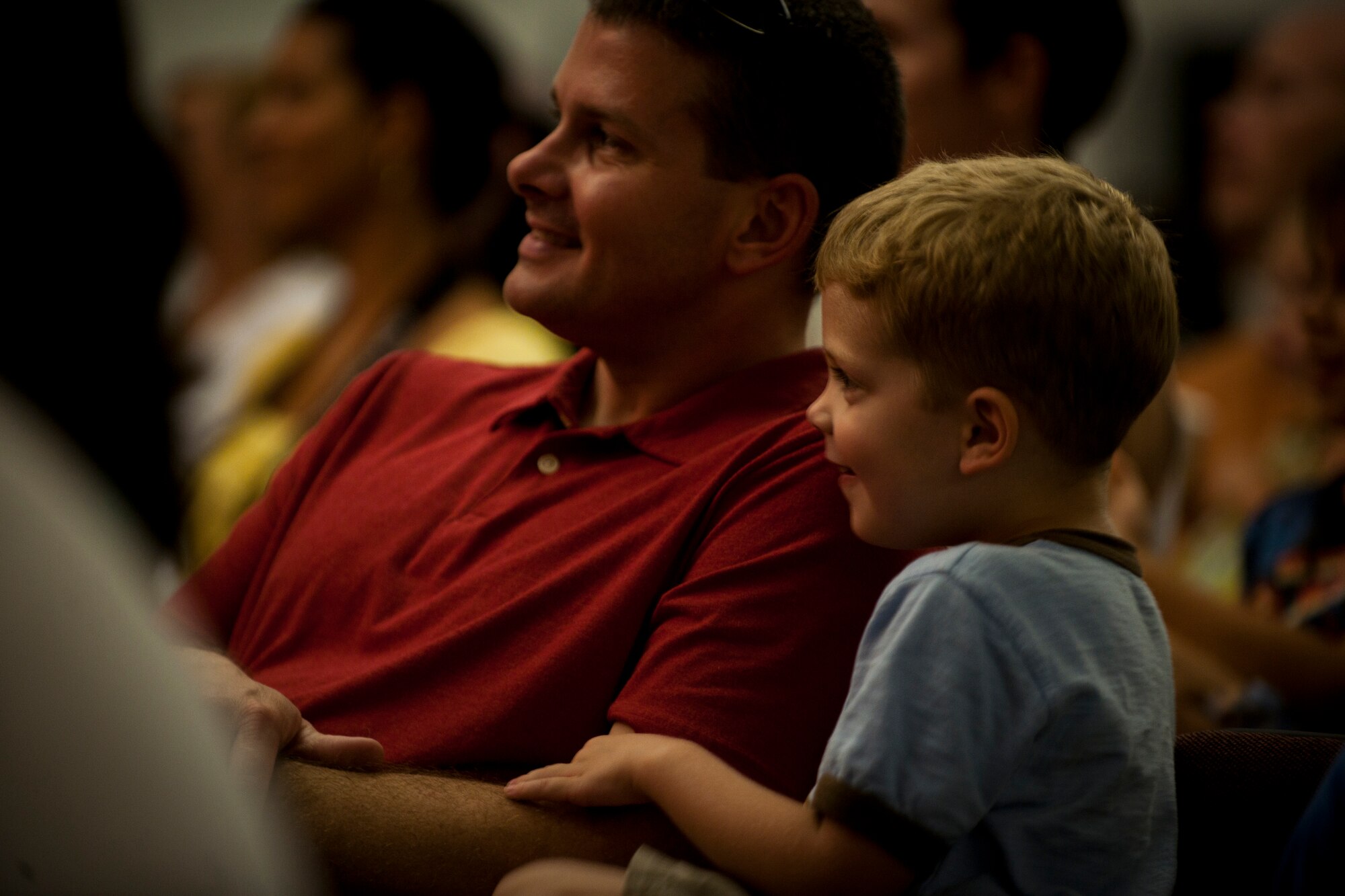 Capt. Lance Vann, left, 728th Air Mobility Squadron, and his son watch a performance of "King Arthur's Quest" Aug. 20, 2011, at the community center at Incirlik Air Base, Turkey. Sixty-four children from the base participated in the play put on by the Missoula Children's Theatre. The theatre visits a variety of public venues to include most stateside and several overseas military installations to teach children about the performing arts. (U.S. Air Force photo by Tech. Sgt. Michael B. Keller/Released)