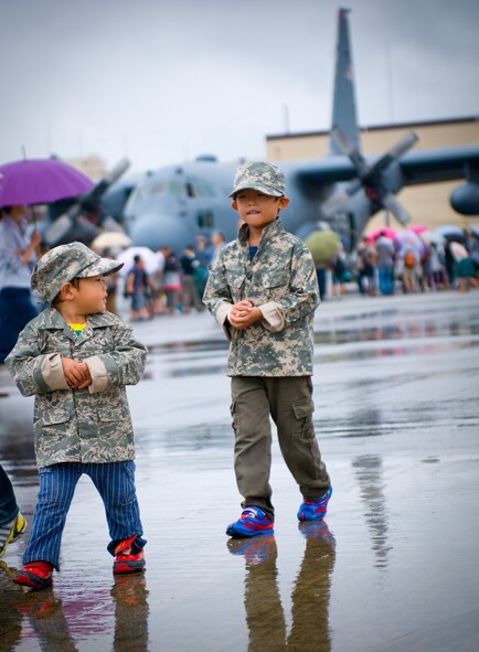 YOKOTA AIR BASE, Japan -- Two young Japanese boys keep warm wearing miniature American military jackets and hats while attending the Japanese-American Friendship Festival at Yokota Air Base, Japan, Aug. 21, 2011. Rain and cloudy weather conditions did little to deter the approximately 117, 000 visitors who attended the festival. (U.S. Air Force photo/Airman 1st Class Krystal M. Garrett) 
