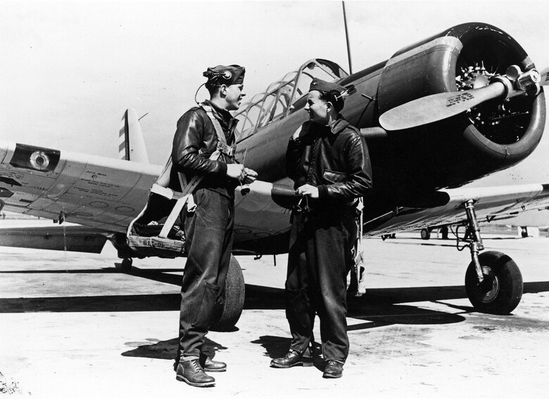 Flight students Jim Leach (left) and Jack Hoover beside a BT-13 basic trainer. Enlisted ground crew personnel formed a silent cheering section for enlisted pilot trainees and showed it in such ways as having a frosty soft drink ready for a sweat-stained student on a hot day. (U.S. Air Force photo)
