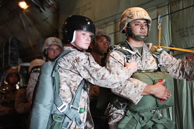 Sgt. Alishia Novey, the operations chief for Air Delivery Platoon, Landing Support Company, Combat Logistics Regiment 17, 1st Marine Logistics Group, supervises the Marines seconds before parachuting over the hills of Camp Pendleton, Calif., Aug. 23. The primary purpose of the jump was to get jump masters qualified for operations.